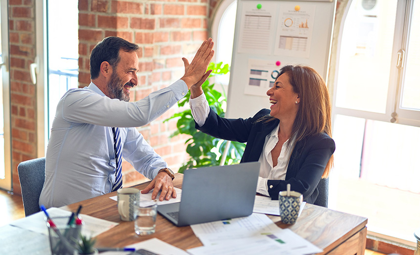 a man and woman giving each other a high five