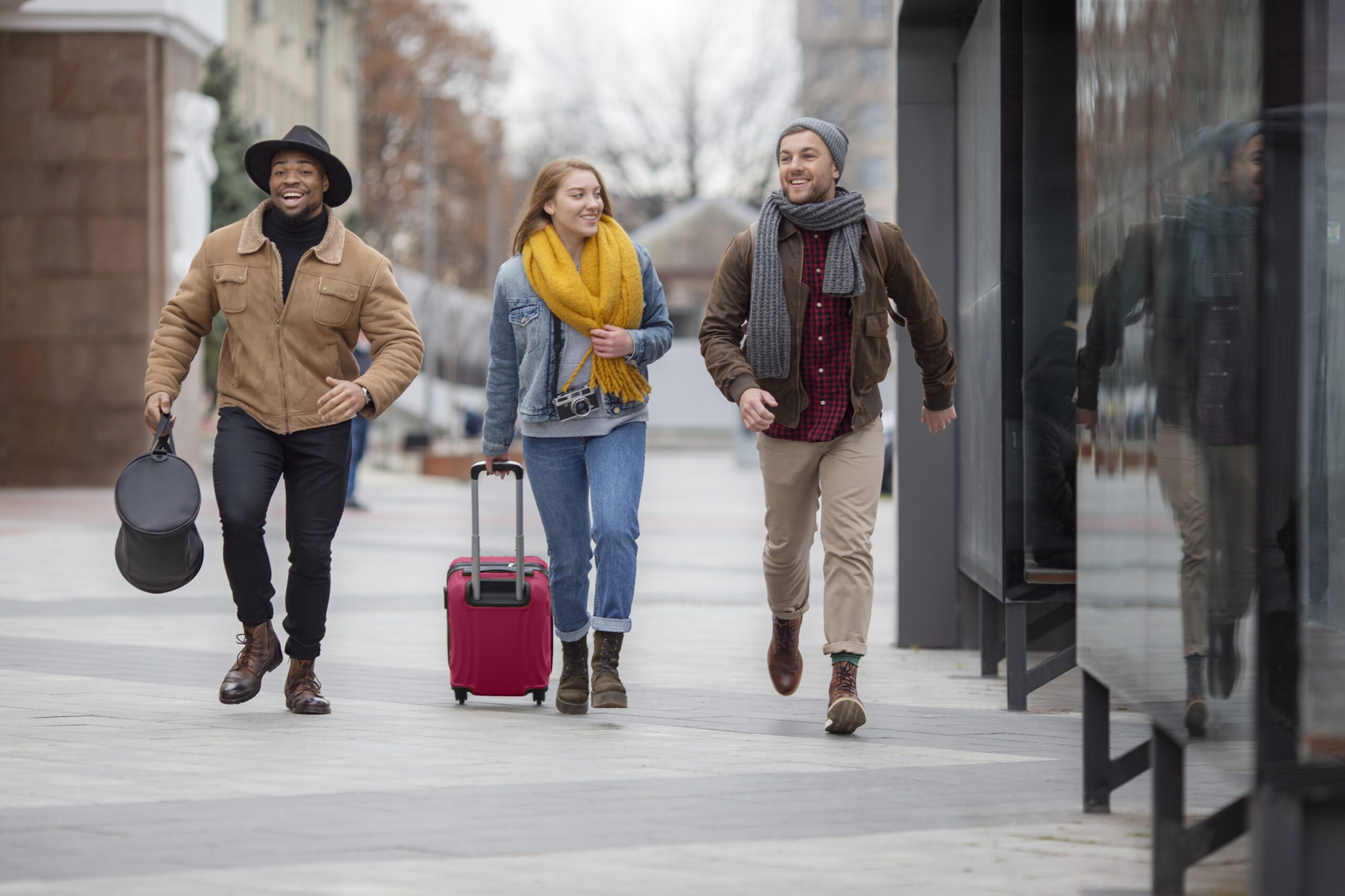 a group of people walking on a sidewalk with luggage